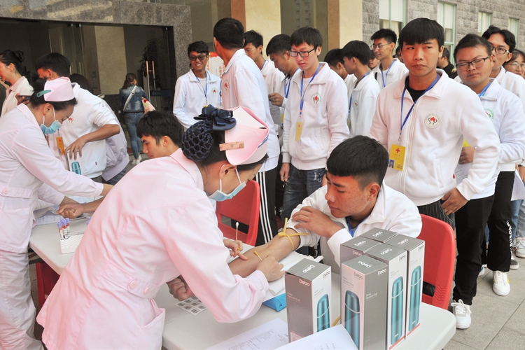 红河州第一个报名造血干细胞捐献者和28个大学生志愿者站在一起